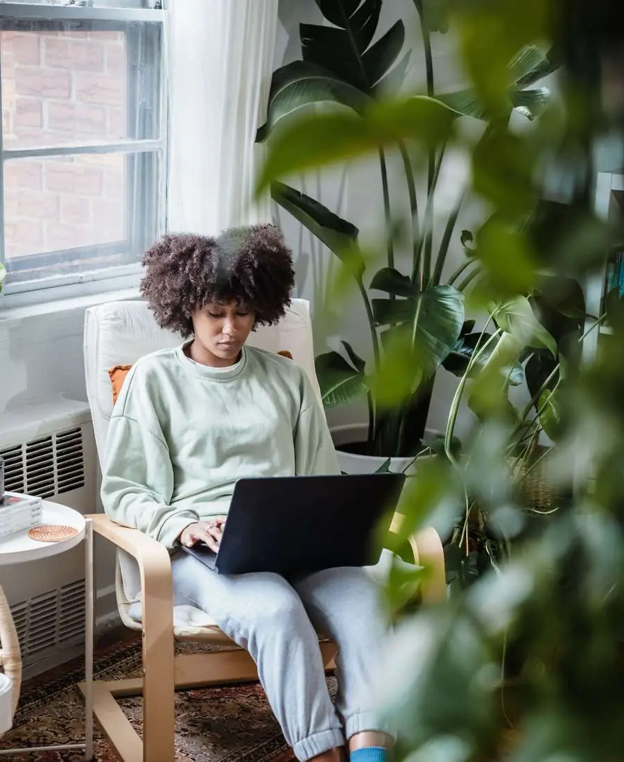 A young woman working on a laptop in a small apartment