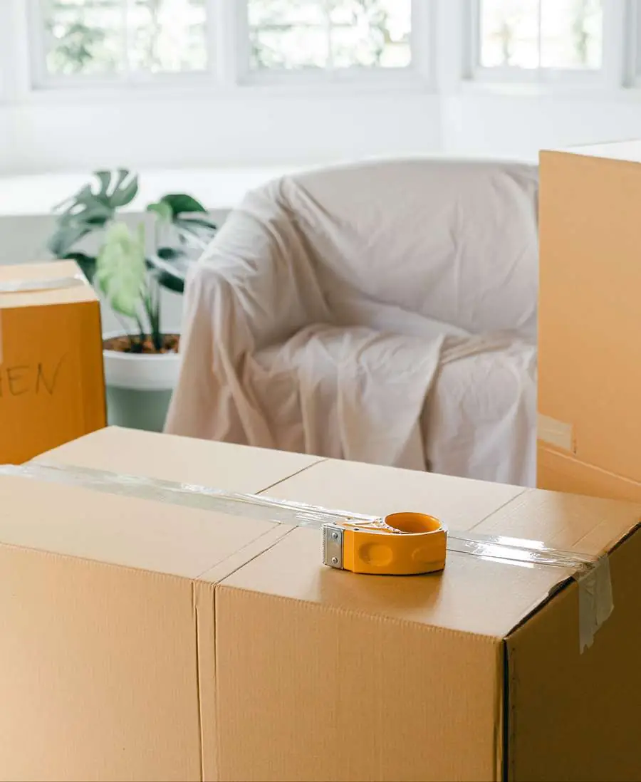 Stacked moving boxes in a bright, mostly empty home