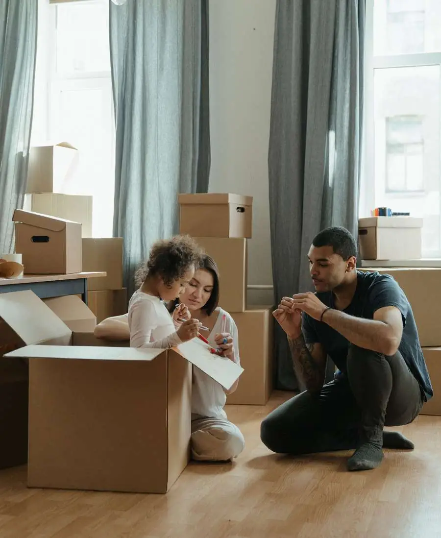 A family unpacking boxes together on the floor of a new home